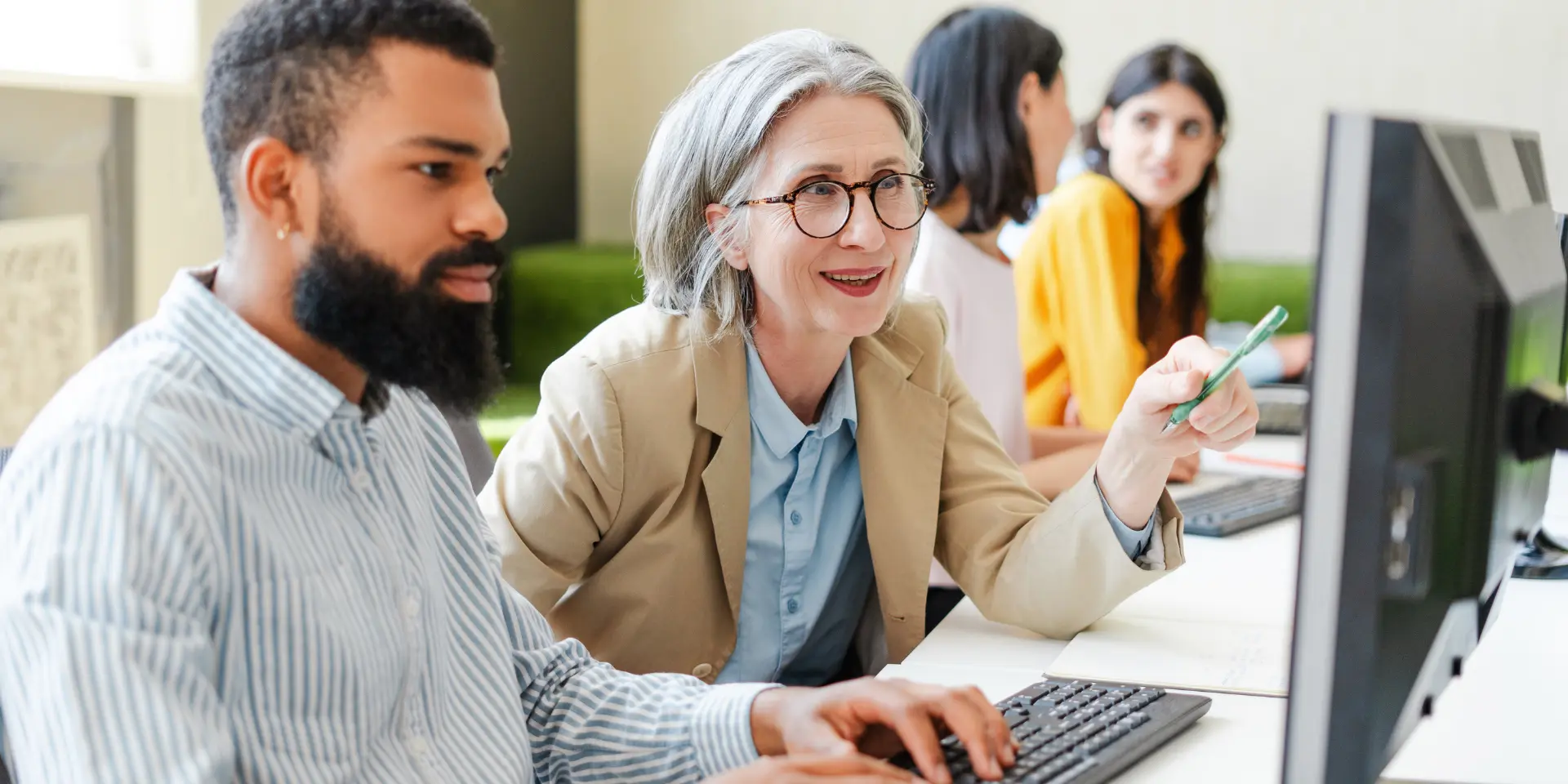 Teachers working on a computer together