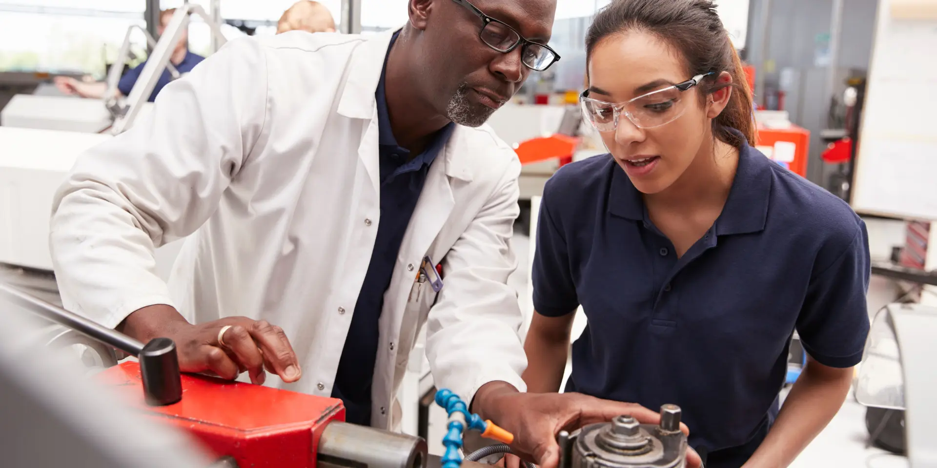 Engineer showing equipment to a female apprentice close up