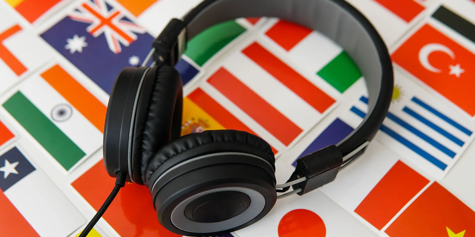 Learning foreign languages online Headphones and countries flags on the background