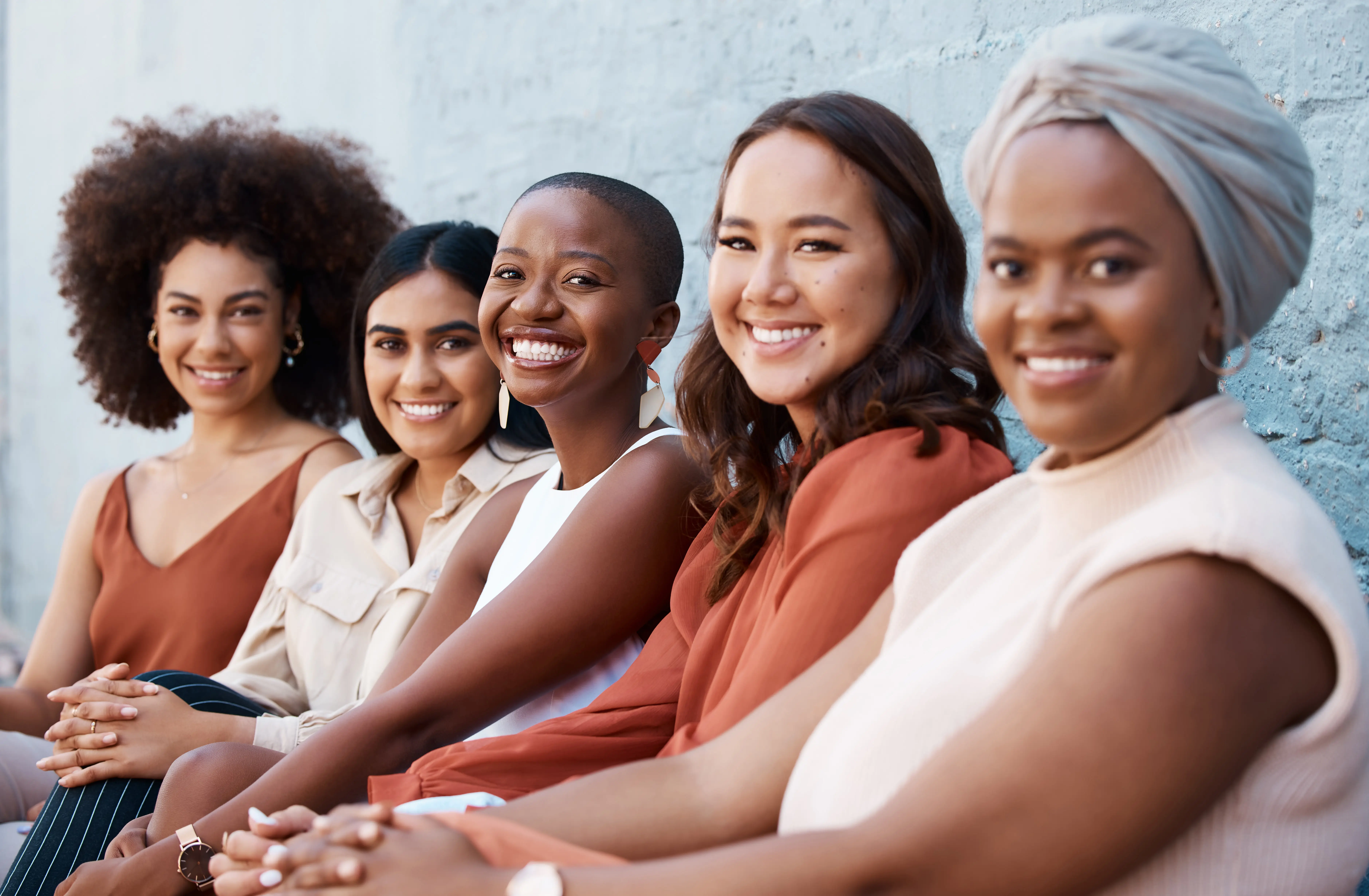 A group of diverse women sitting and smiling