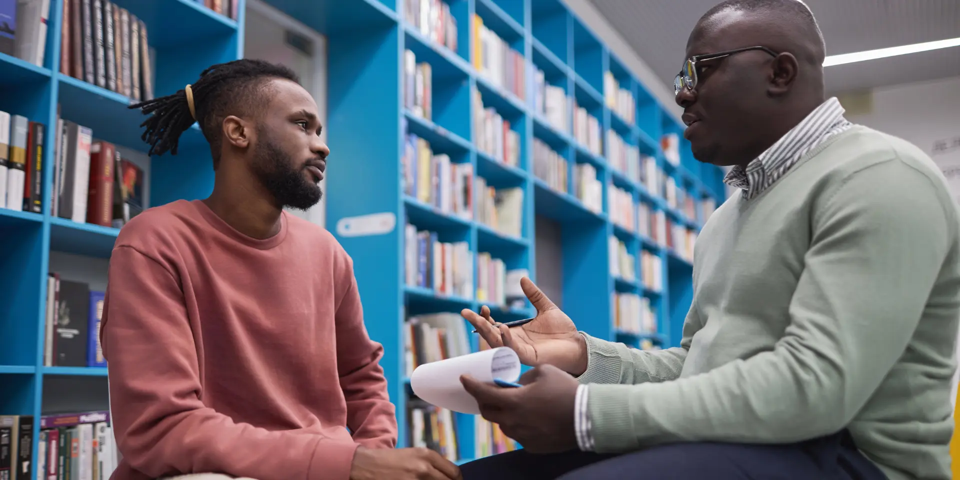 African American male therapist talking to student in mental health session