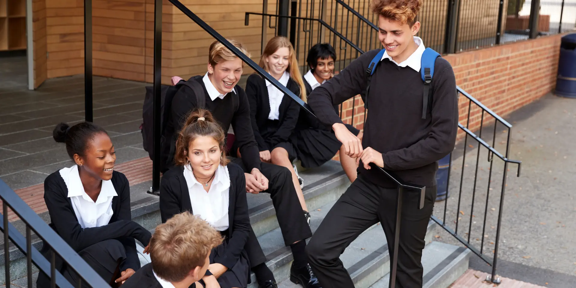 Group Of Teenage Students In Uniform Outside School Building