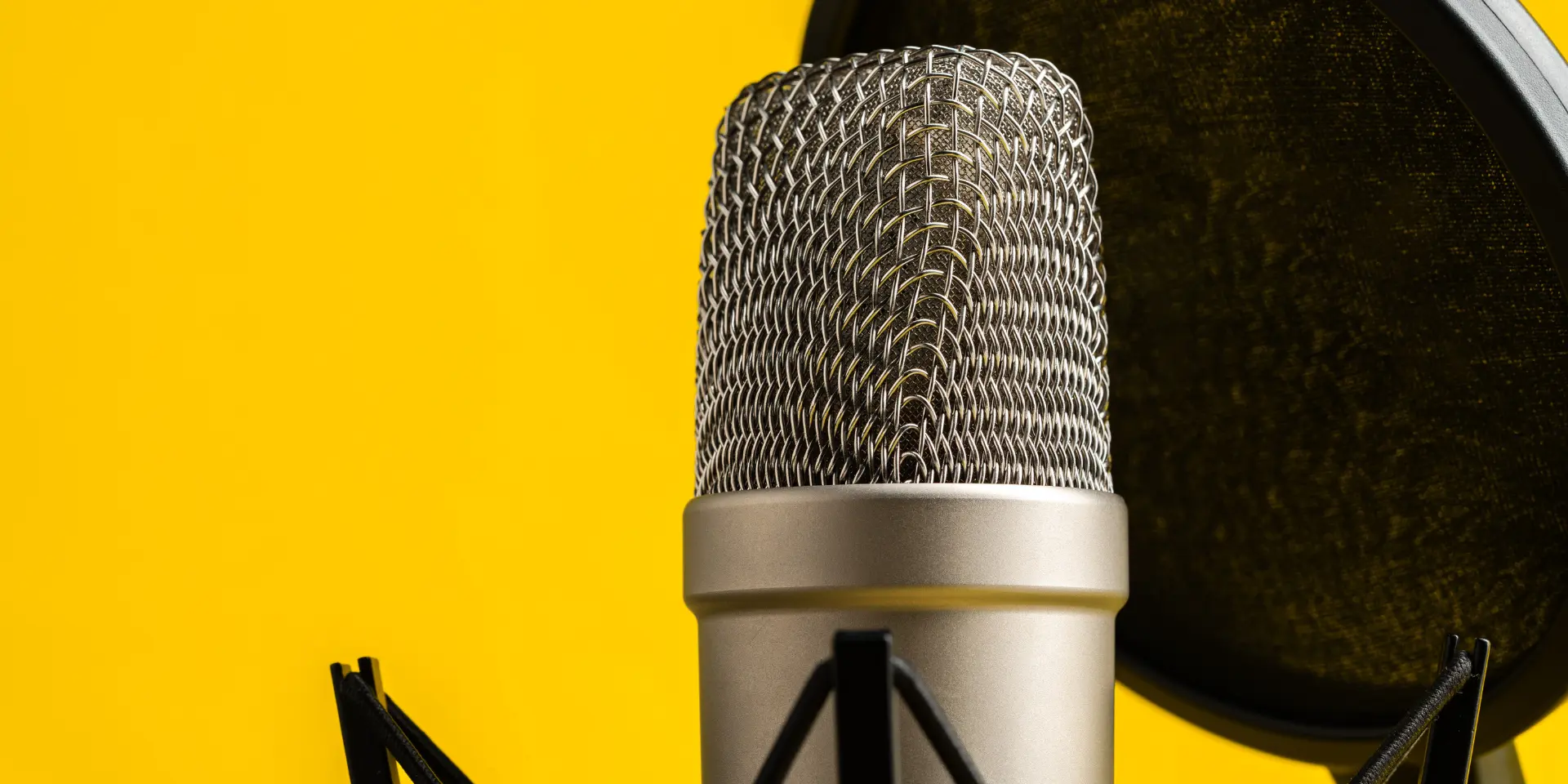 Professional microphone stand over yellow studio background