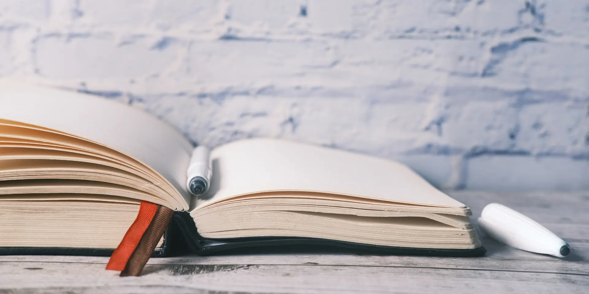 Open book and a pen on on table with copy space