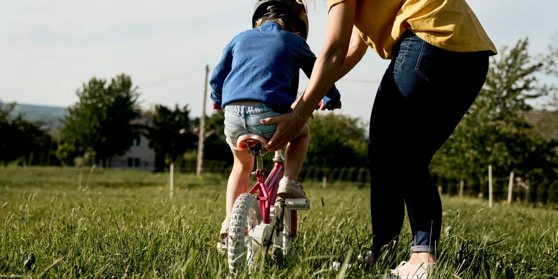 Caucasian woman with toddler learning how to ride bike