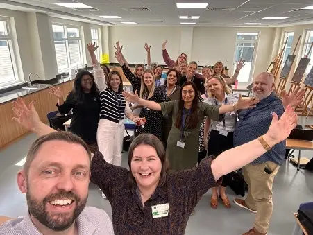 a group of lexonik trainers and teachers with their hands in the air celebrating a successful mass training event