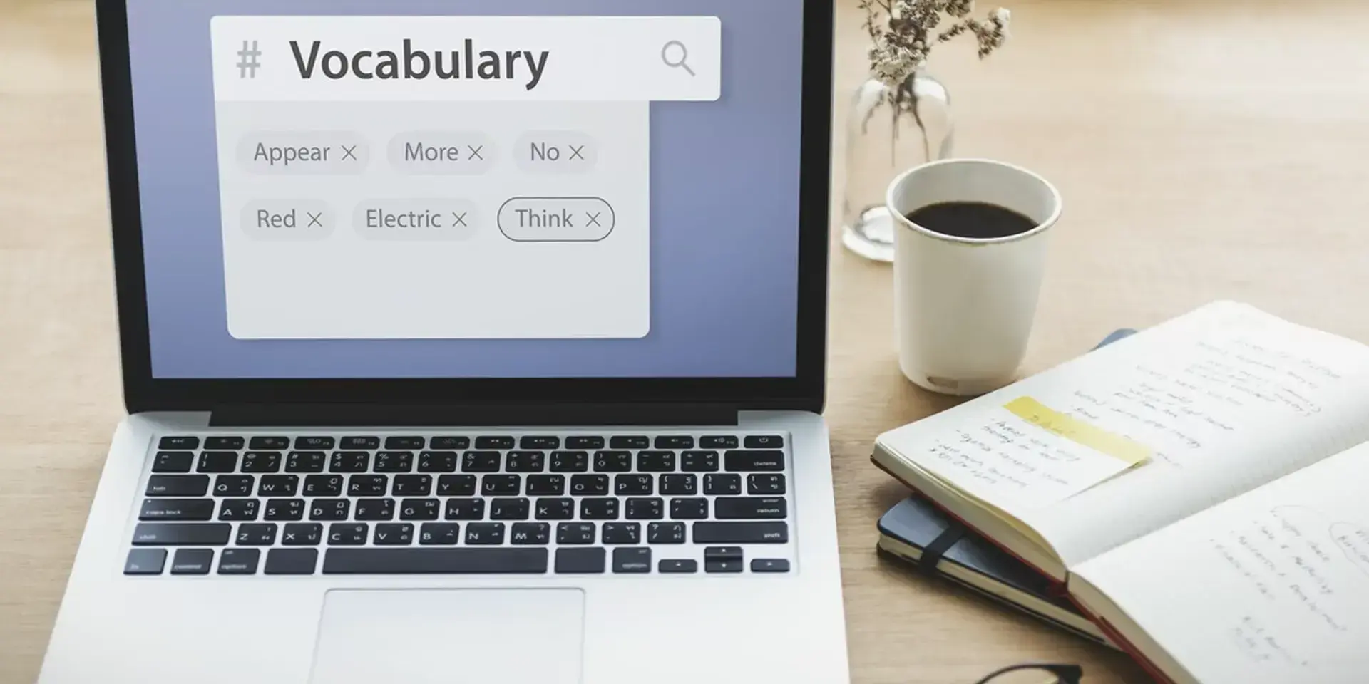 a laptop on a desk with someone searching for the word vocabulary on the screen