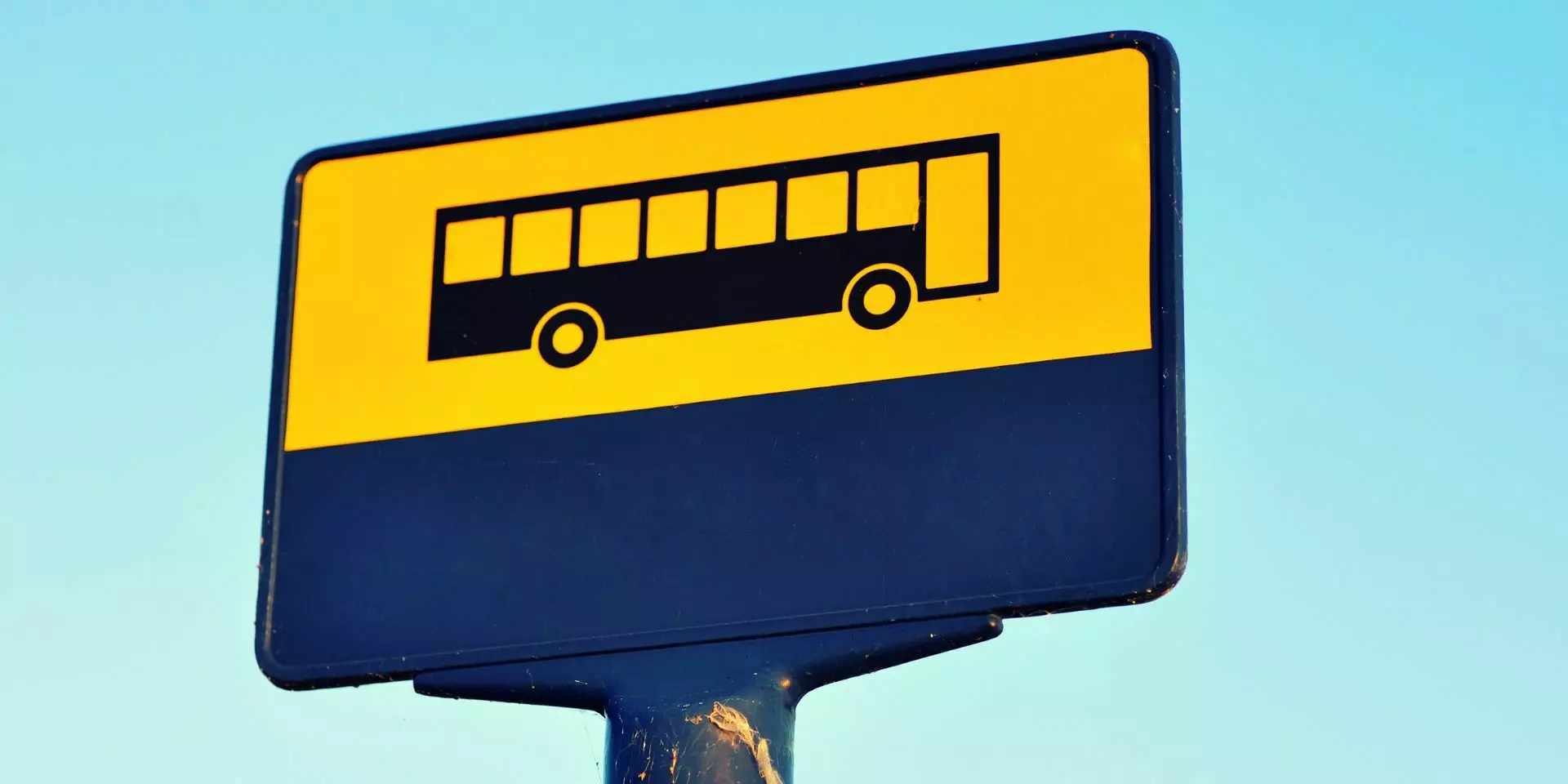 a yellow sign with a bus silhouette at the top