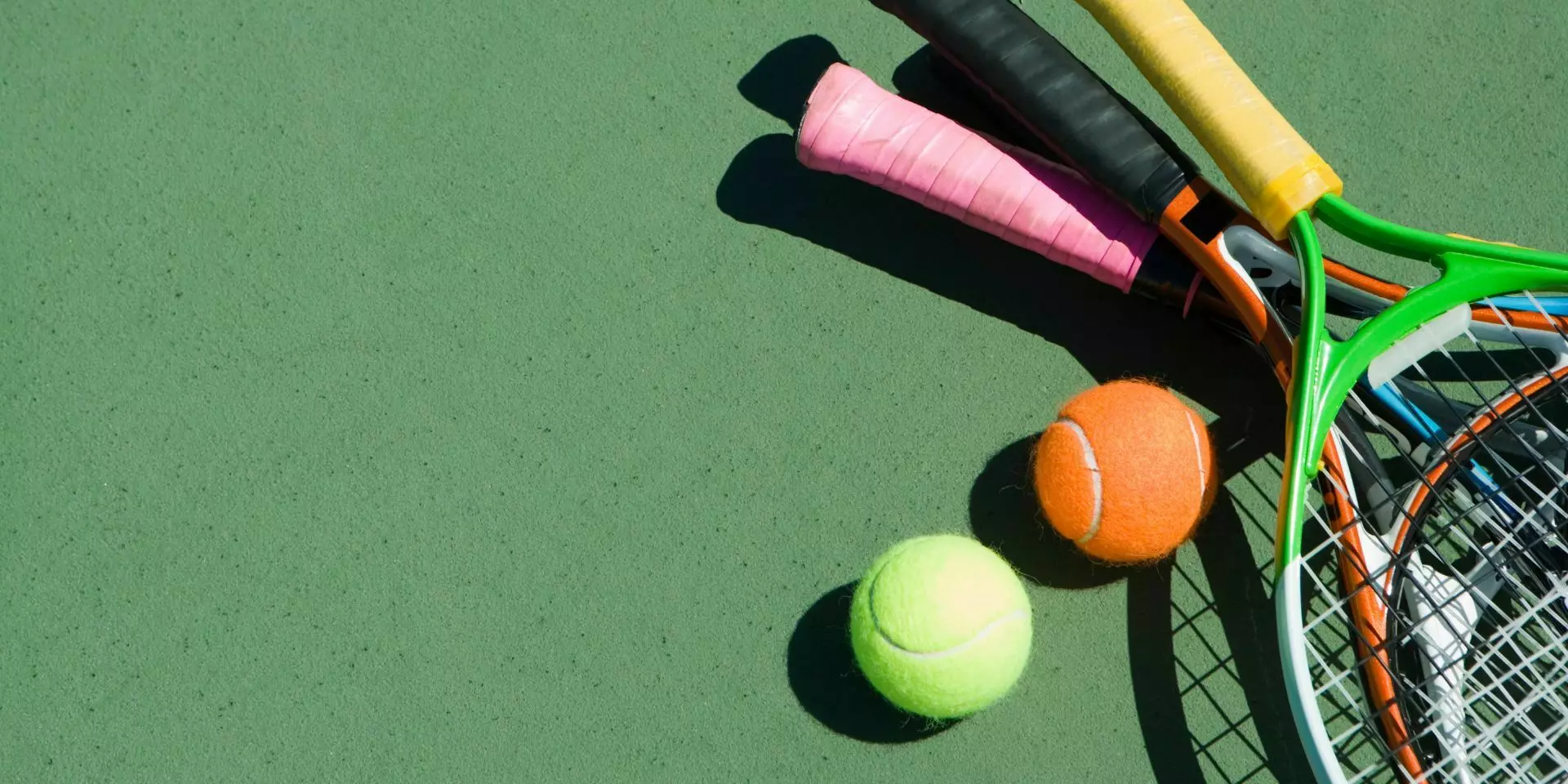 tennis balls and rackets on the floor of a tennis court