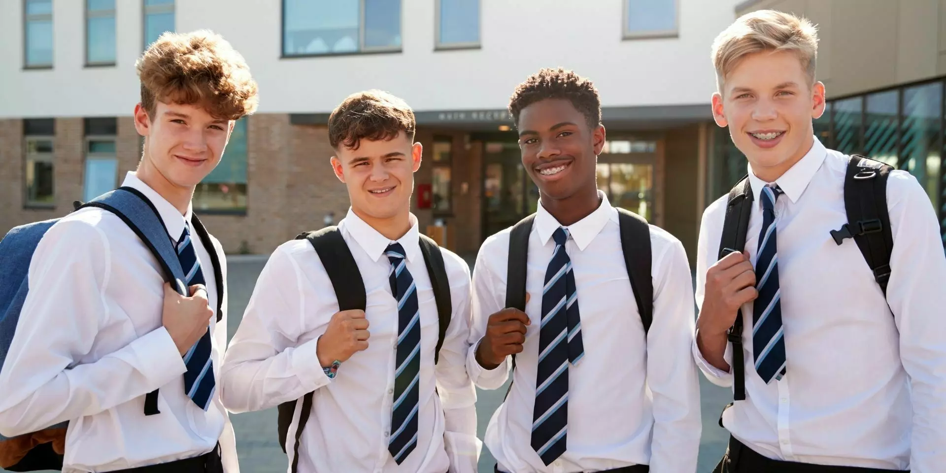 four secondary school students stood outside of school